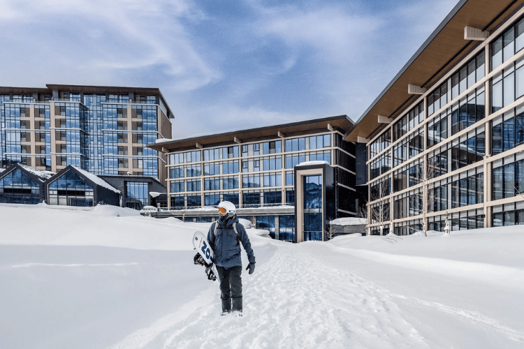 snowboarder walking outside of Park Hyatt Niseko Hanazono